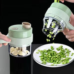 Handheld vegetable chopper with green vegetables on a plate against a black background